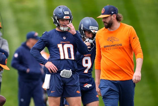 Denver Broncos quarterback Bo Nix, left, confers with quarterback coach Davis Webb during the NFL football team's rookie minicamp, Saturday, May 11, 2024, in Centennial, Colo. (AP Photo/David Zalubowski)