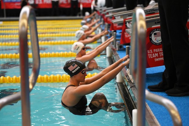 Elizabeth Marks, bottom, hangs off the starting block before the women's 100 backstroke at the 2024 U.S. Paralympic Swim Team Trials in Minneapolis, Thursday, June 27, 2024. (AP Photo/Jackson Ranger)