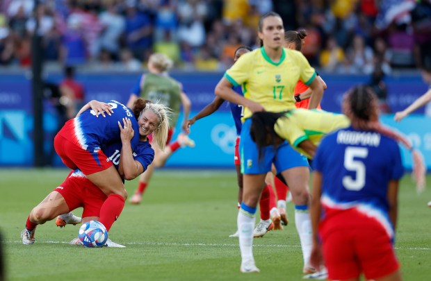 Lindsey Horan of the United States, center, celebrates with her teammates after winning the women's soccer gold medal match between Brazil and the United States at the Parc des Princes during the 2024 Summer Olympics, Saturday, Aug. 10, 2024, in Paris, France. (AP Photo/Aurelien Morissard)