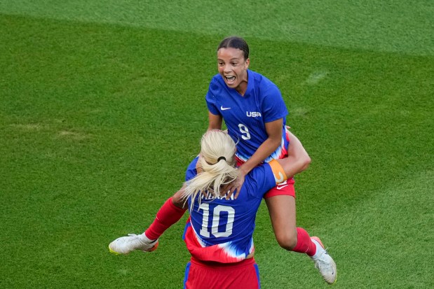 Mallory Swanson, of the United States, up, celebrates with Lindsey Horan, of the United States, after scoring her side's first goal during the women's soccer gold medal match between Brazil and the United States at the Parc des Princes during the 2024 Summer Olympics, Saturday, Aug. 10, 2024, in Paris, France. (AP Photo/Vadim Ghirda)