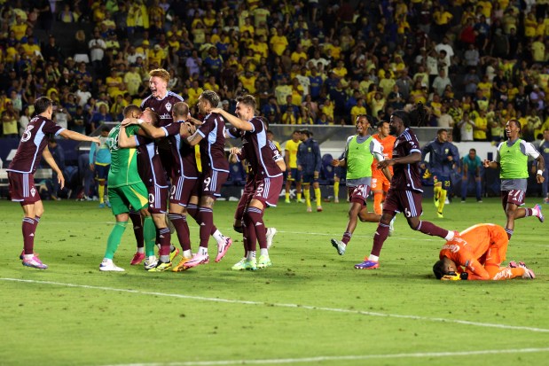 Colorado Rapids teammates celebrate as Club America goalkeeper Luis Malagón, bottom right, reacts on the ground after Malagón missed a penalty shot during the penalty shootout of a Leagues Cup quarterfinal soccer match Saturday, Aug. 17, 2024, in Carson, Calif. (AP Photo/Raul Romero Jr.)