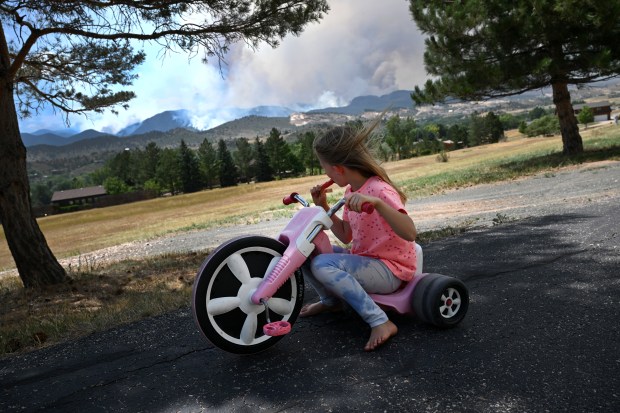 Lizzy Mann, 8, eats a popsicle while watching the Alexander Mountain fire from her grandparents house off of Glade Road west of Loveland on July 30, 2024. (Photo by Helen H. Richardson/The Denver Post)