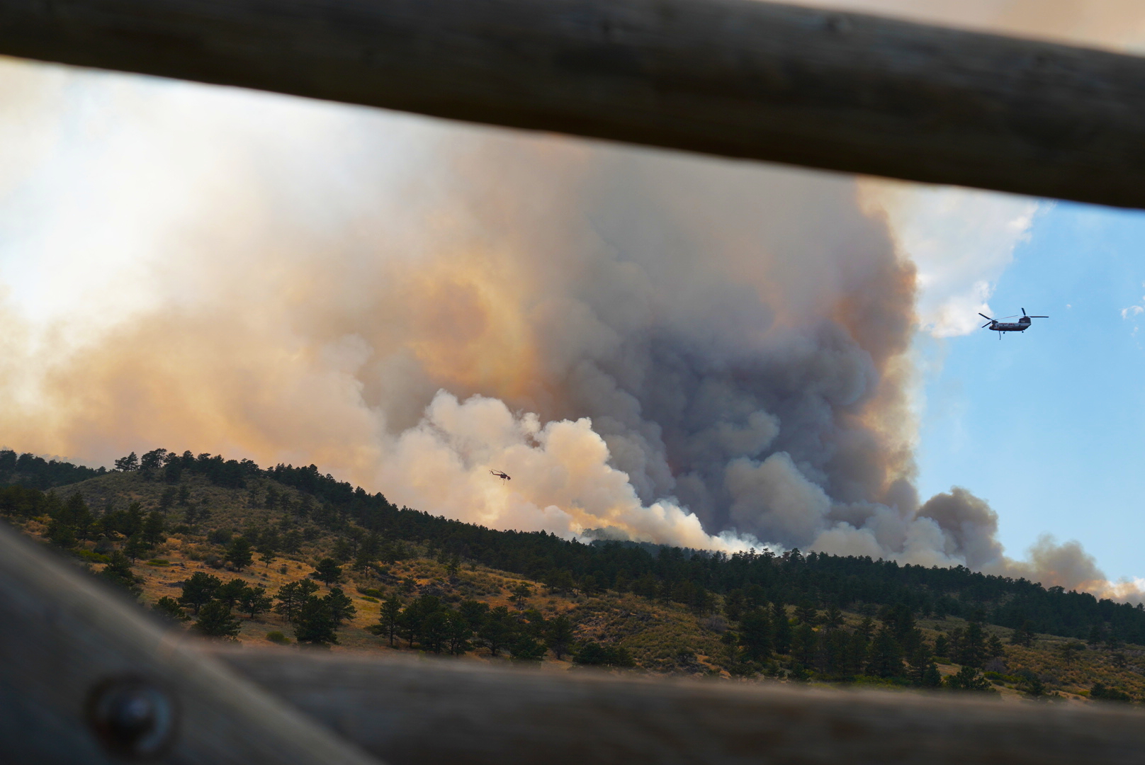 Two helicopter fly into position to dump water on the Alexander Mountain fire west of Loveland on Monday, July 29, 2024. (Photo by Zachary Spindler-Krage/The Denver Post)