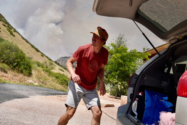 Evan Mann puts essentials into the car as he and his wife, Deborah, pack up their house as they evacuate from the Alexander Mountain fire west of Loveland on Tuesday, July 30, 2024. Their house off of County Road 27 was roughly a mile from the closest portion of the fire. (Photo by Zachary Spindler-Krage/The Denver Post)