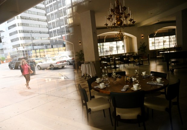 A woman walks down the street as the interior of Ellyngton's Restaurant can be seen to the right at the Brown Palace Hotel in Denver on Sept. 4, 2024. (Photo by Helen H. Richardson/The Denver Post)