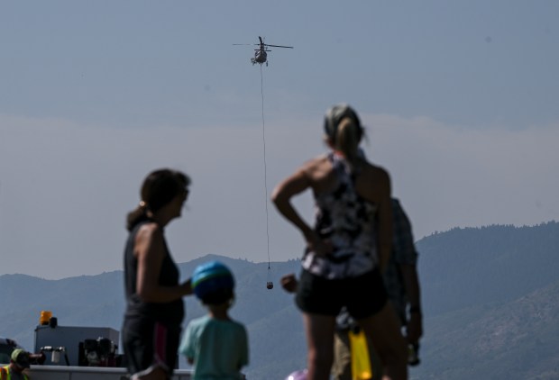 People watch while crews work in Ken Caryl as the Quarry fire burns near Littleton on Thursday, Aug. 1, 2024. (Photo by AAron Ontiveroz/The Denver Post)