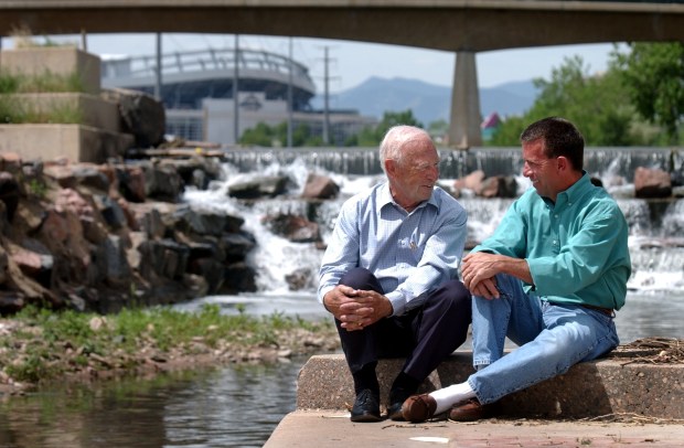 Joe Shoemaker, left, a former state legislator, and his son Jeff sit on the banks of the South Platte River on May 29, 2002, in Denver. In 1974, Joe persuaded then-Mayor Bill McNichols to spend $2 million and form a committee to finally begin cleaning up 100 years' worth of pollution and waste dumped in the river. The committee became the Greenway Foundation, which would eventually be run by Jeff Shoemaker. (Photo by Kathryn Scott/The Denver Post)