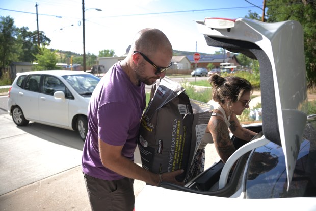 David Glover, left, and his wife Taylor pack for evacuation in Lyons on Tuesday, July 30, 2024. (Photo by Hyoung Chang/The Denver Post)