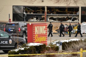 Law enforcement officers wait outside the ...