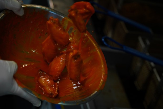 Dylan Patton tosses wings in the kitchen of Vine Street Pub & Brewery on Thursday, June 13, 2024. (Photo by Zachary Spindler-Krage/The Denver Post)