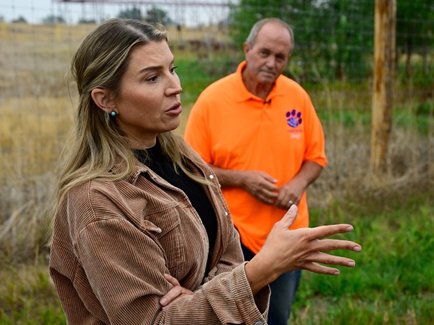 Cats Aren't Trophies campaign director Samantha Miller, left, talks to reporters during a media tour at The Wild Animal Sanctuary in Keenesburg, Colorado, on Friday, Aug. 9, 2024. Pat Craig, Founder of The Wild Life Sanctuary, right, listens. (Photo by Andy Cross/The Denver Post)