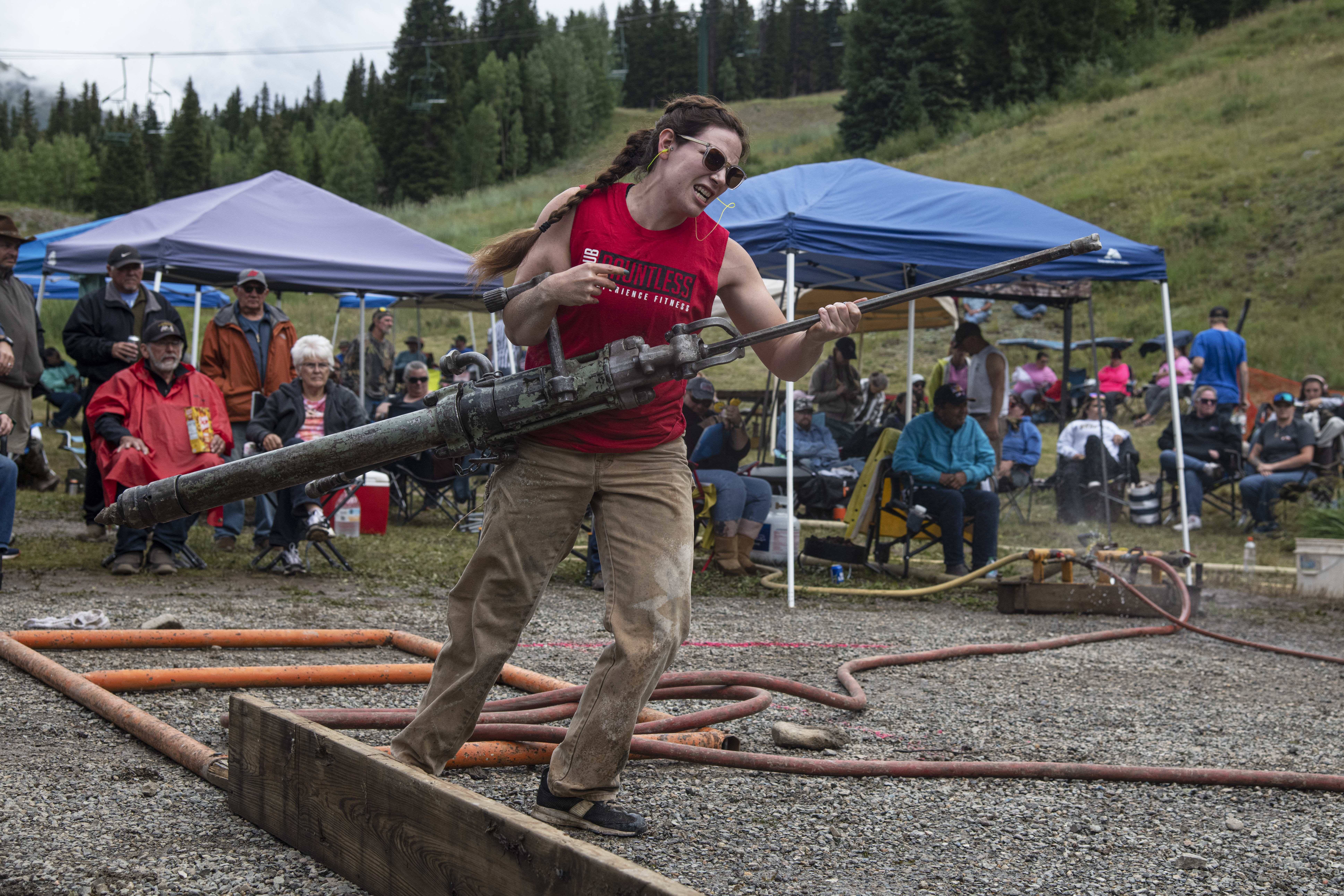 Silverton native LiErin Wilson hauls a jackleg drill to start drilling into rock during team drilling competition at the 50th Hardrockers' Holidays in Silverton on Sunday, Aug. 11, 2024. (Photo by William Woody/Special to The Denver Post)