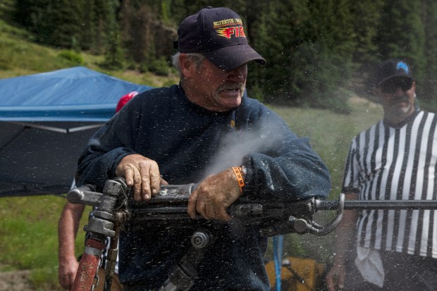 Silverton native Terry Rhoades works a jackleg drill while competing in the single man drilling competition at the 50th Hardrockers' Holidays in Silverton on Saturday, Aug. 10, 2024. (Photo by William Woody/Special to The Denver Post)