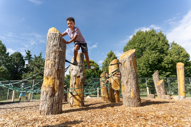 Children play on wooden structures inspired by Colorado's wild spaces at Denver Museum of Nature & Science's Nature Play playground, a 4-acre interactive installation in City Park. (Photo by Rick Wicker, provided by DMNS)