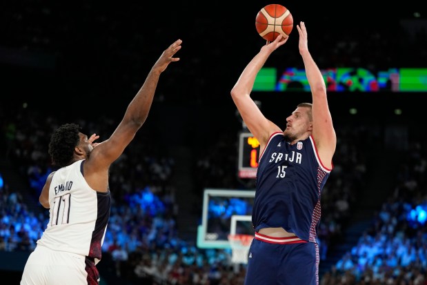 Nikola Jokic (15), of Serbia shoots over United States' Joel Embiid (11) during a men's semifinals basketball game at Bercy Arena at the 2024 Summer Olympics, Thursday, Aug. 8, 2024, in Paris, France. (AP Photo/Michael Conroy)