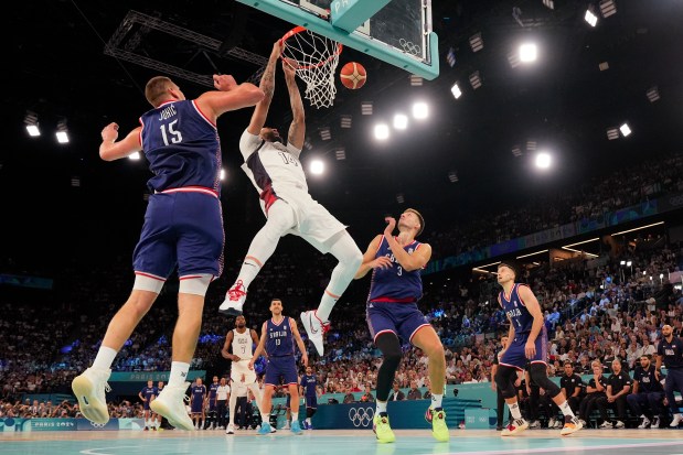 United States' Anthony Davis (14) dunks over Serbia during a men's semifinals basketball game at Bercy Arena at the 2024 Summer Olympics, Thursday, Aug. 8, 2024, in Paris, France. (AP Photo/Mark J. Terrill)