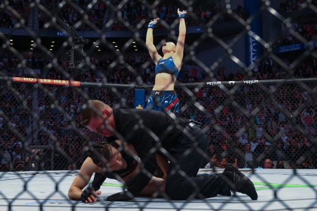 Rose Namajunas celebrates as the referee kneels over Zhang Weili during a UFC 261 mixed martial arts bout Saturday, April 24, 2021, in Jacksonville, Fla. (AP Photo/Gary McCullough)